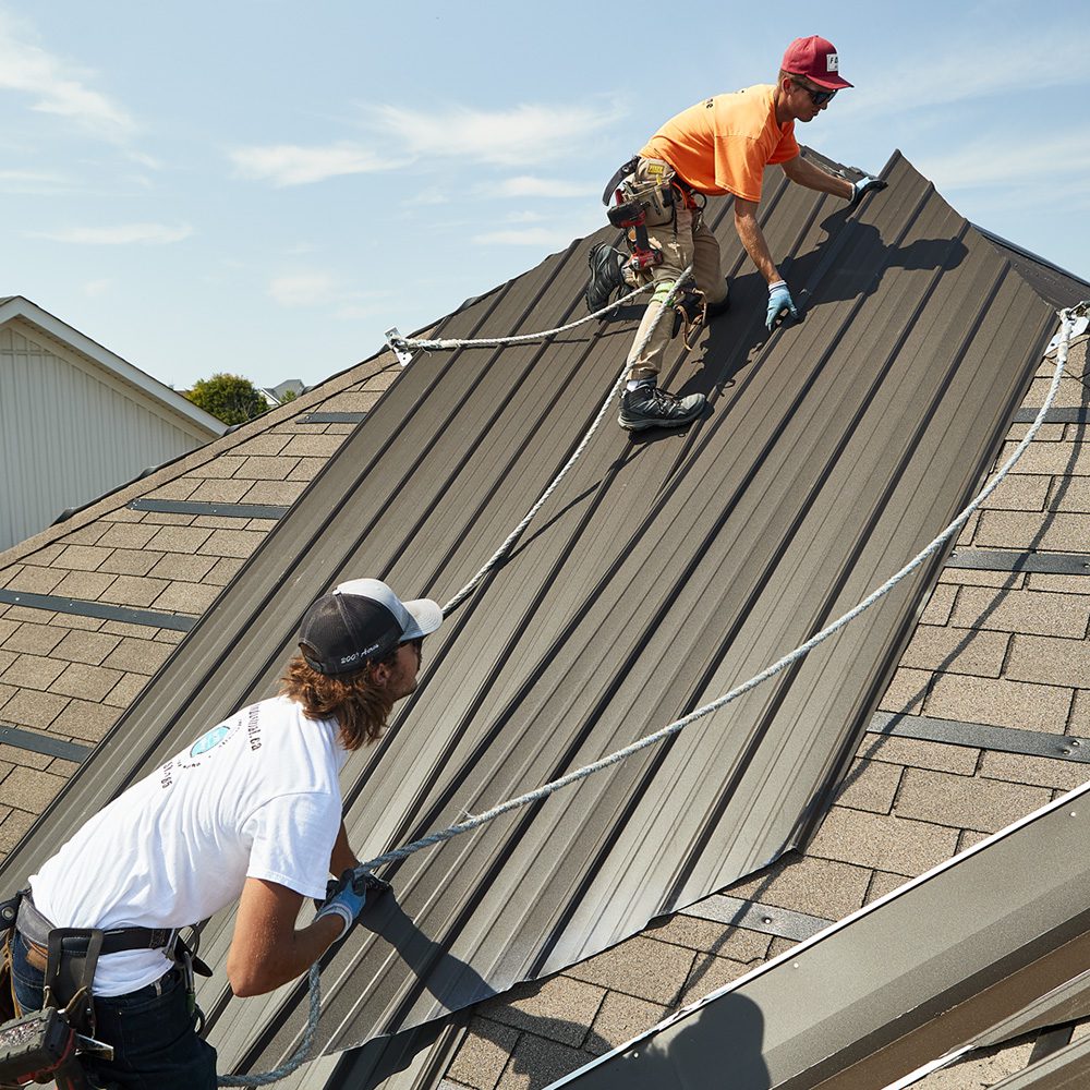 roofing company employees installing a metal roof in cobourg